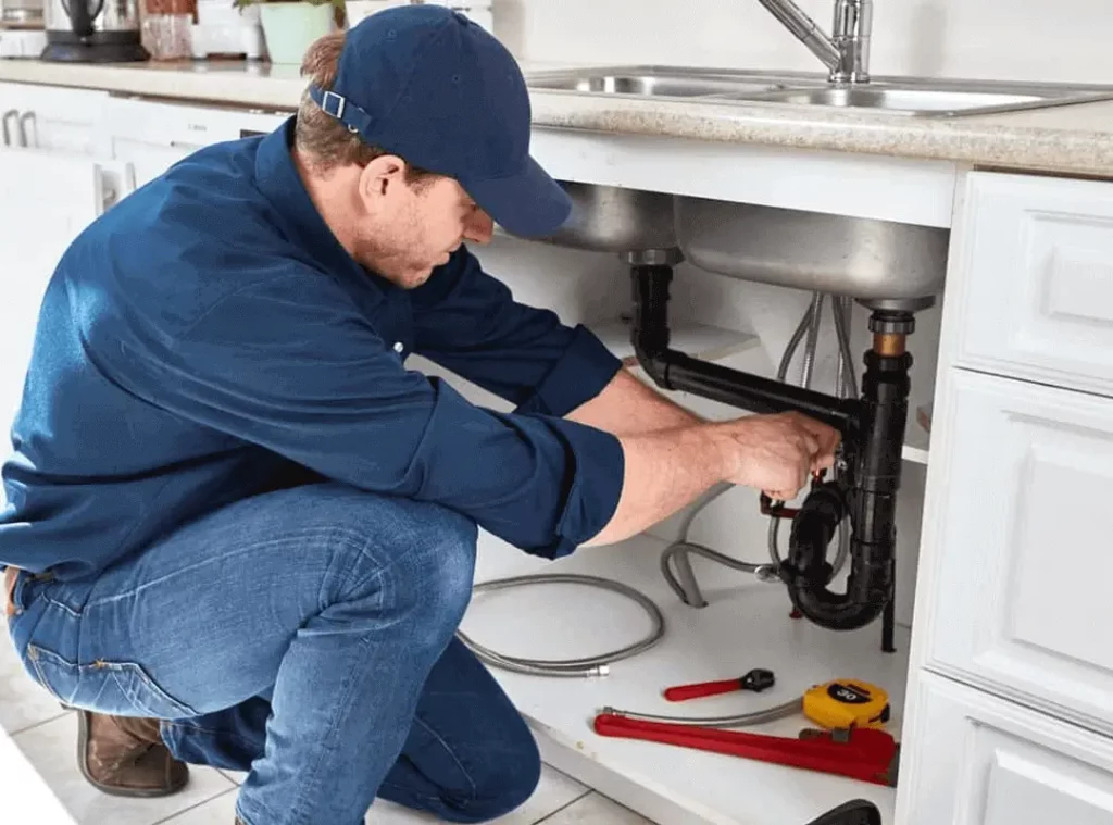 Professional plumber working on pipes